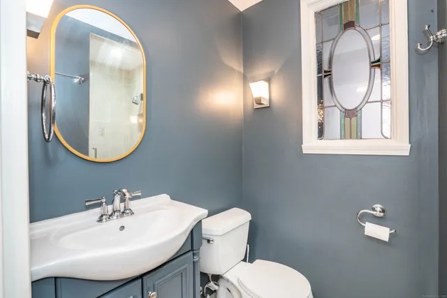 a bathroom with a toilet sink and mirror