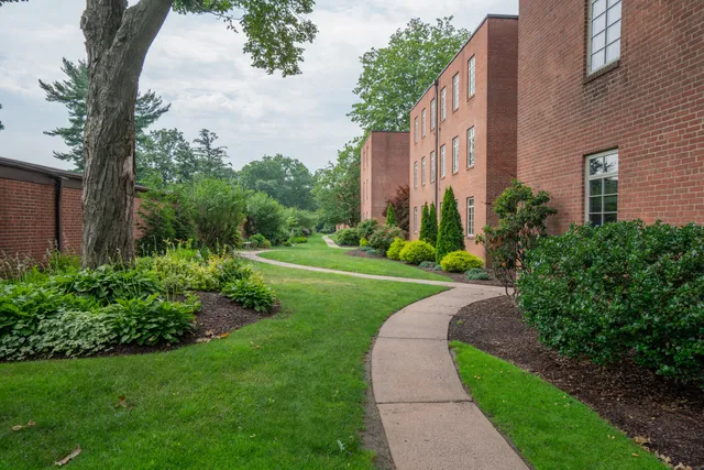 a view of a tall brick building next to a yard