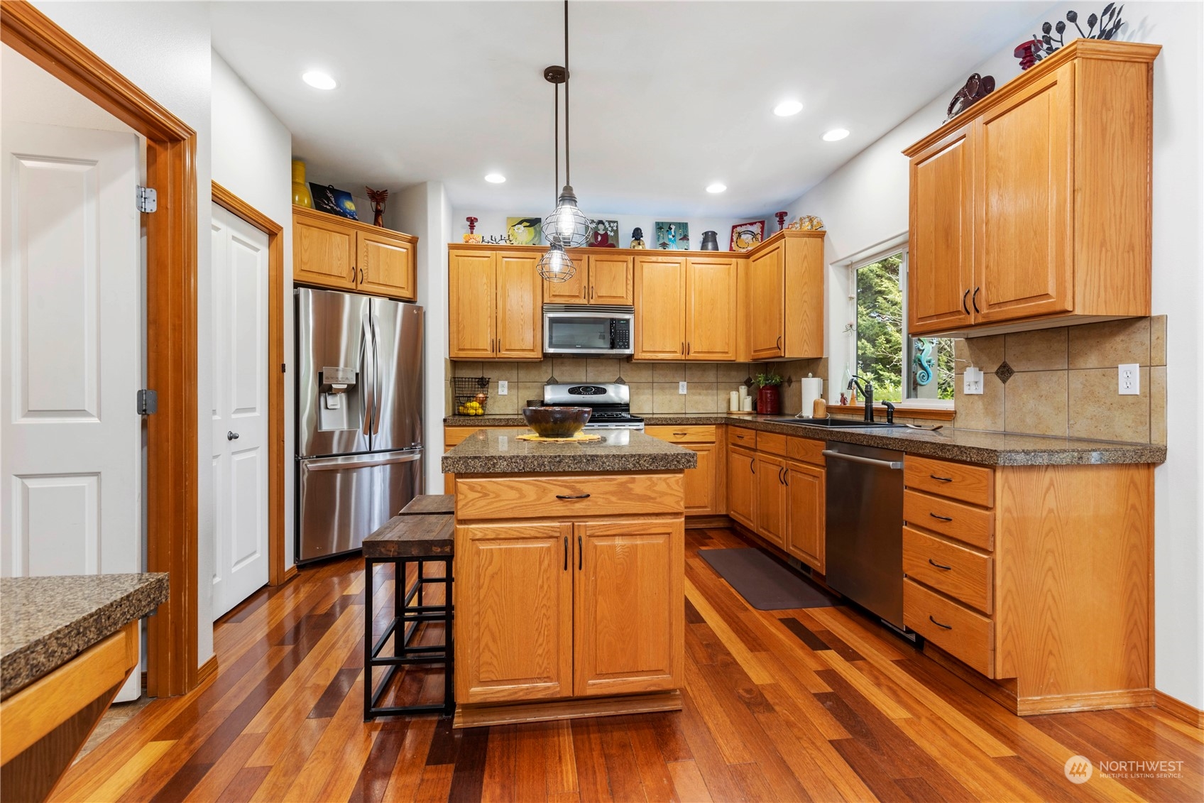 4712 152nd Place Southeast Bothell, WA 98012 - Photo 16 of 31 a kitchen with stainless steel appliances granite countertop a refrigerator a stove top oven a sink dishwasher and wooden cabinets with wooden floor