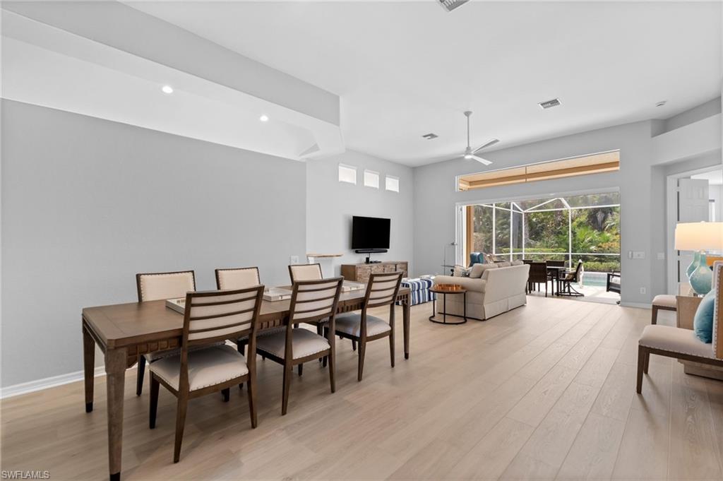1717 Winding Oaks Way Naples, FL 34109 - Photo 6 of 29 a living room with furniture a flat screen tv and a table