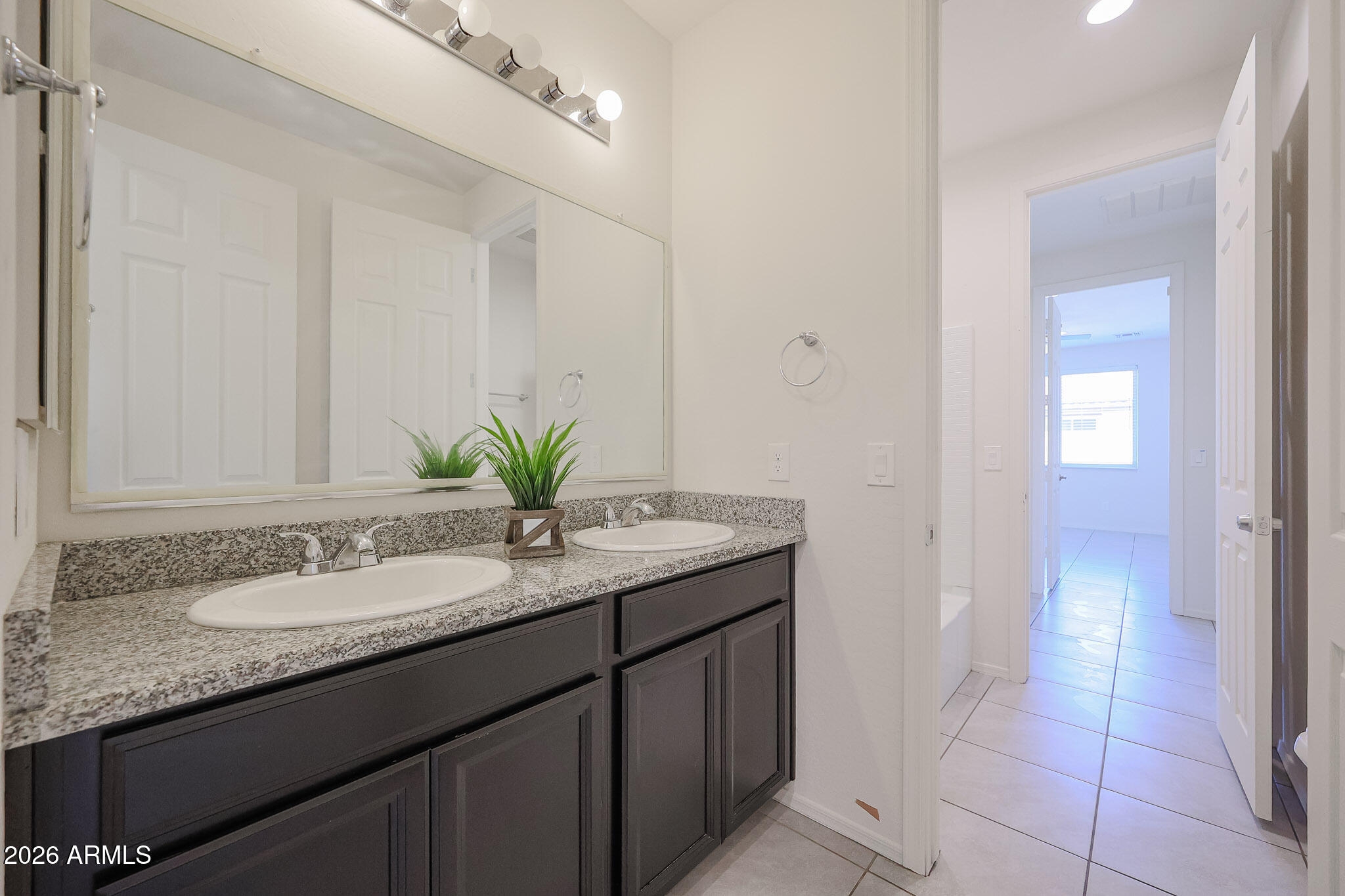17592 West Hadley Street Goodyear, AZ 85338 - Photo 13 of 20 a bathroom with a granite countertop sink and a mirror
