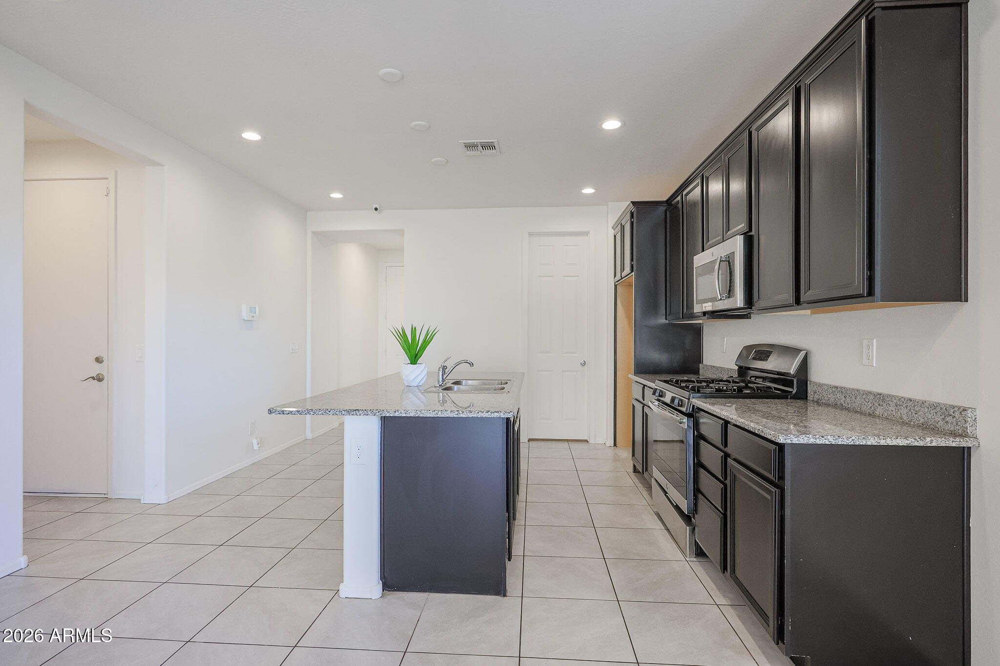 17592 West Hadley Street Goodyear, AZ 85338 - Photo 2 of 20 a kitchen with stainless steel appliances granite countertop a stove a sink and a refrigerator