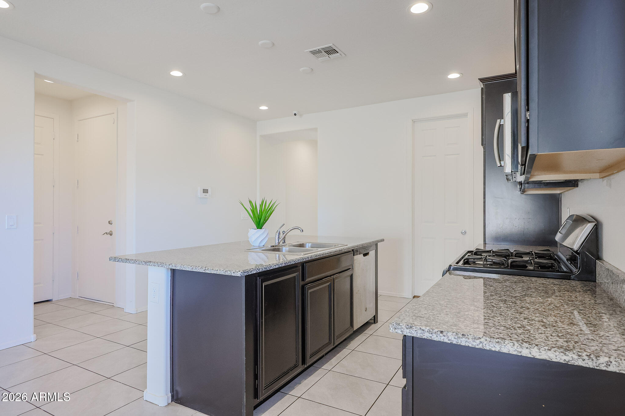 17592 West Hadley Street Goodyear, AZ 85338 - Photo 3 of 20 a kitchen with stainless steel appliances granite countertop a stove a sink and a refrigerator