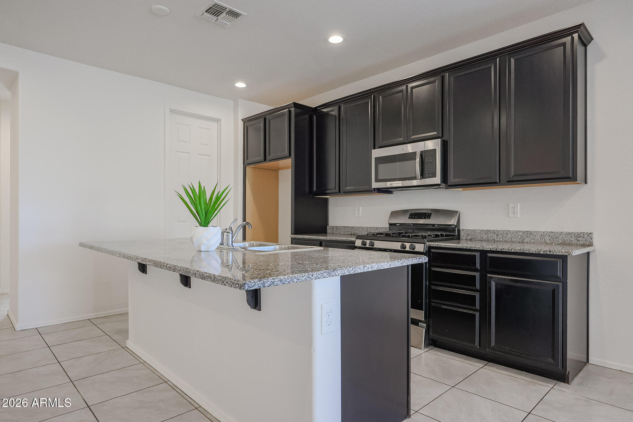 17592 West Hadley Street Goodyear, AZ 85338 - Photo 4 of 20 a kitchen with stainless steel appliances a stove sink and microwave