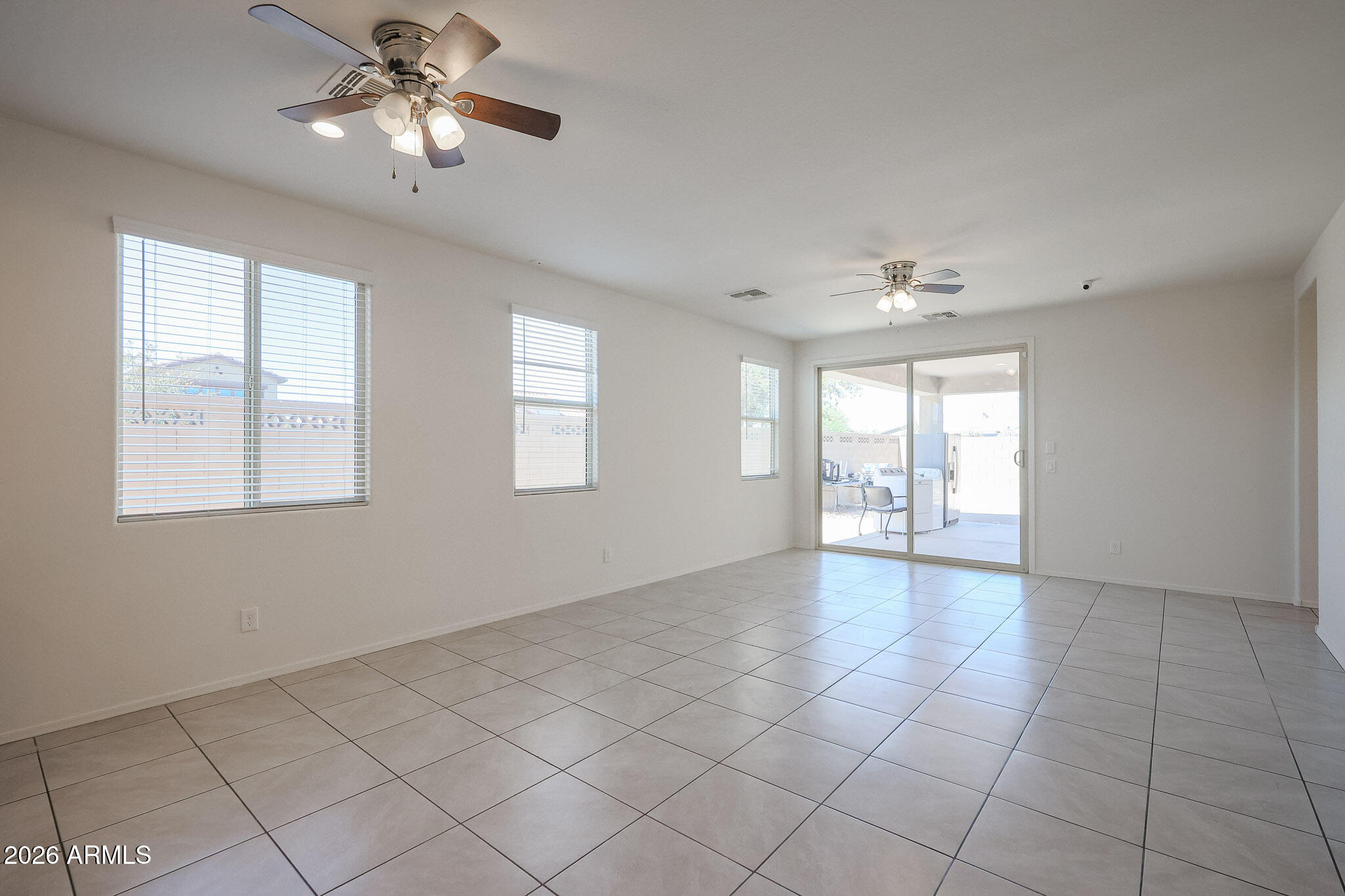 17592 West Hadley Street Goodyear, AZ 85338 - Photo 5 of 20 a view of an empty room with a chandelier fan and fire place