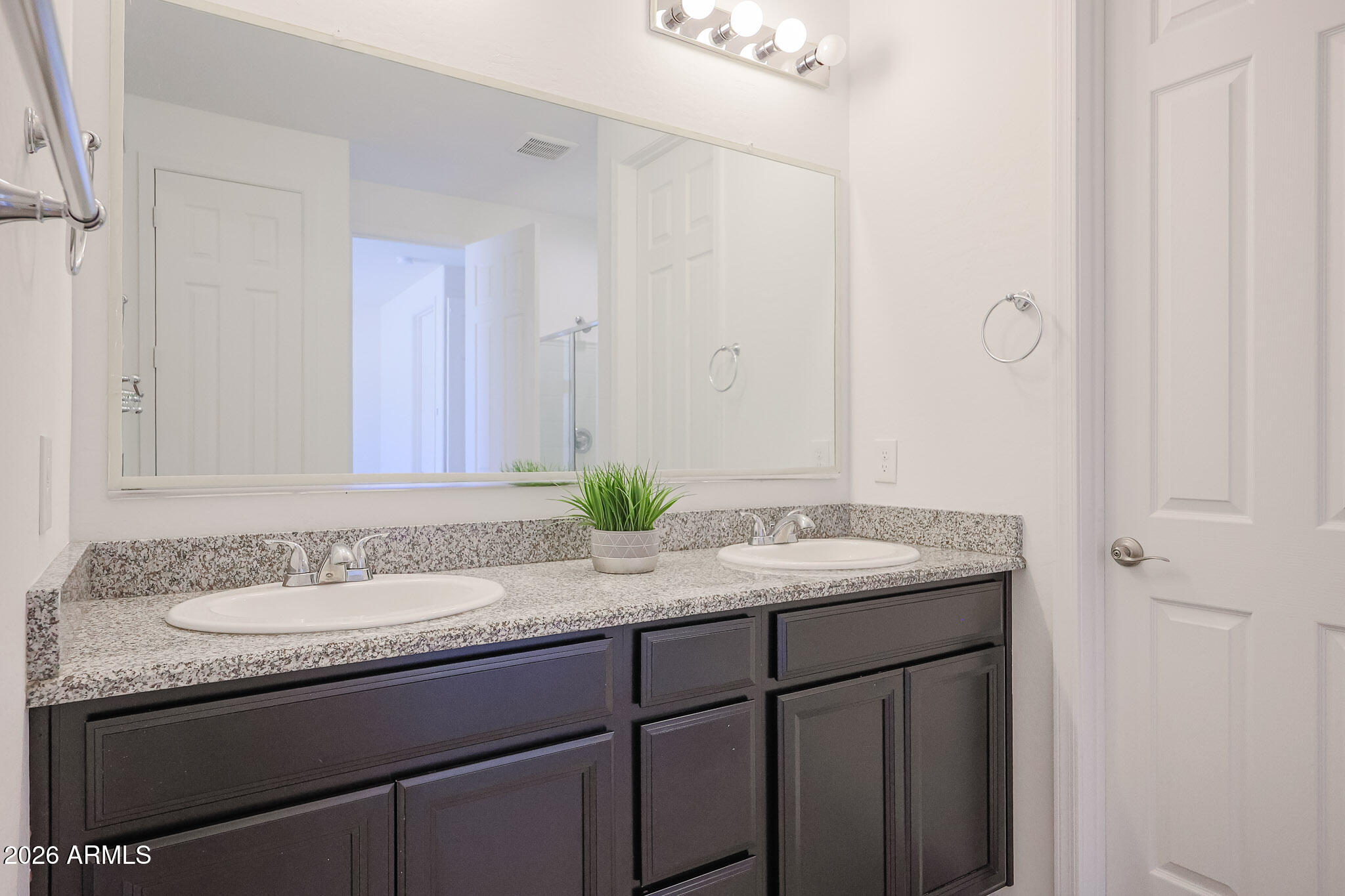 17592 West Hadley Street Goodyear, AZ 85338 - Photo 9 of 20 a bathroom with a granite countertop sink and a mirror
