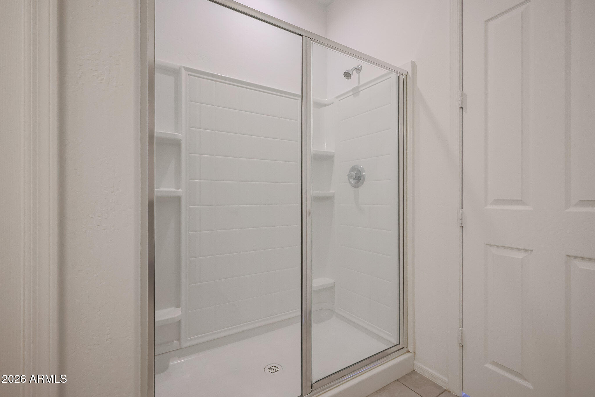 17592 West Hadley Street Goodyear, AZ 85338 - Photo 10 of 20 a bathroom with a glass shower door