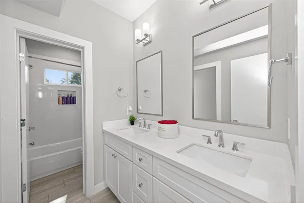 a bathroom with a tub a sink and mirror