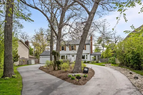a front view of a house with a yard and fountain