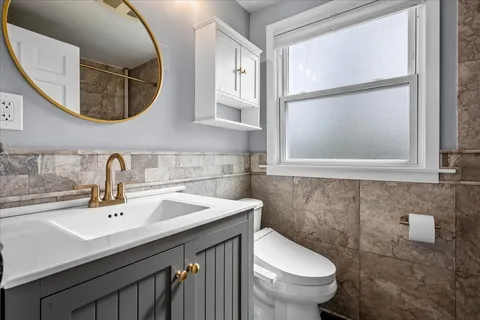 a bathroom with a sink mirror and toilet