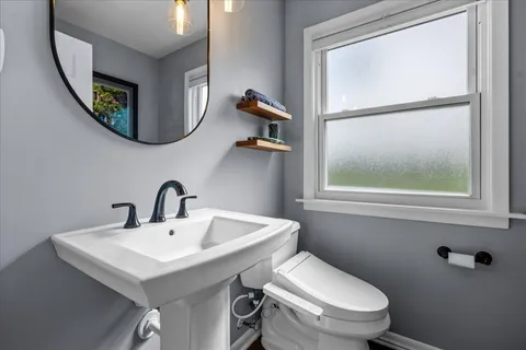a bathroom with a toilet a sink and a mirror