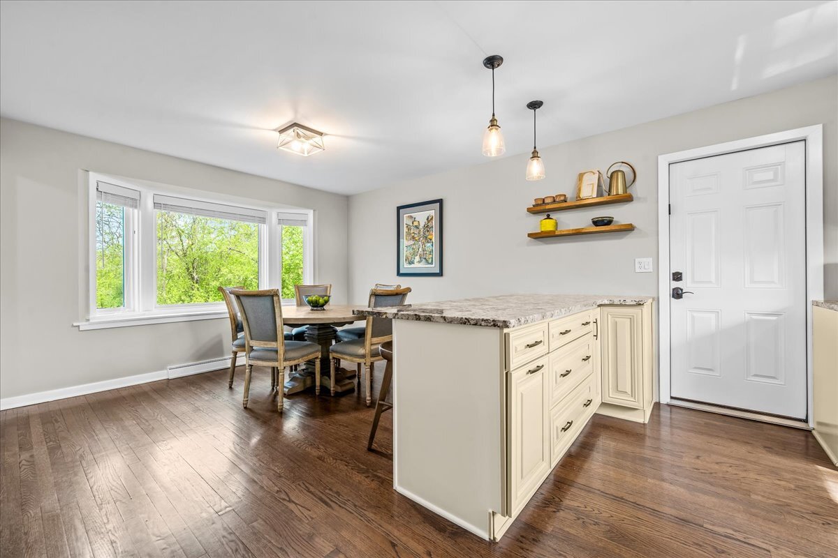 1541 Wilmot Road Deerfield, IL 60015 - Photo 10 of 25 a kitchen with granite countertop a refrigerator a stove a dining table and chairs with wooden floor