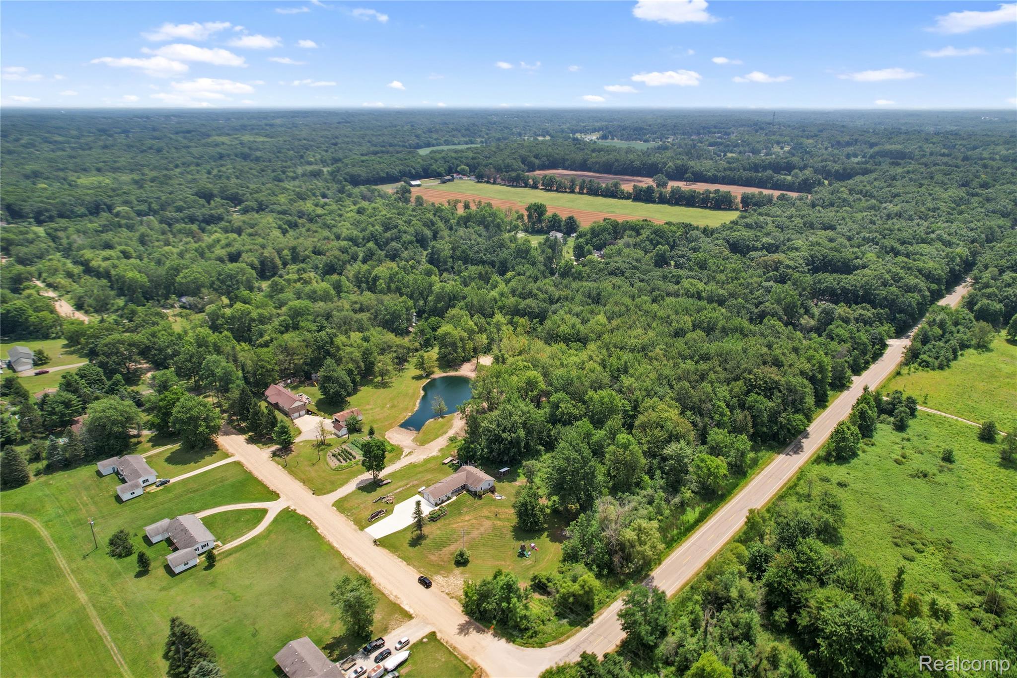 6050 Brophy Road Howell, MI 48855 - Photo 26 of 27 Expansive aerial view showcasing a significant treed area with a serene pond feature