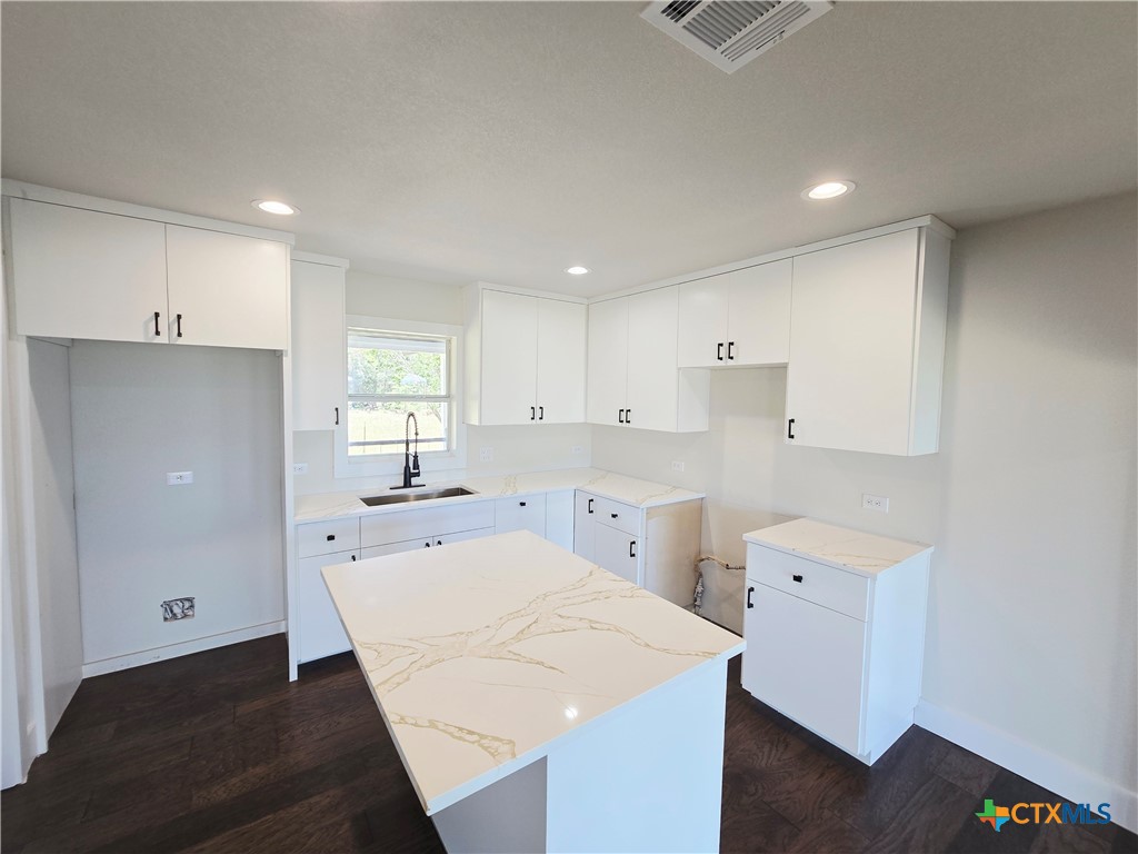 930 Elm Creek Road Rockdale, TX 76567 - Photo 14 of 25 a large white kitchen with wooden floor