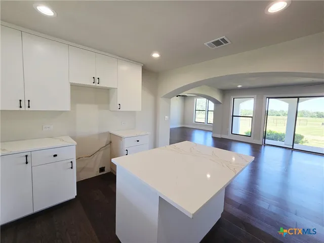 a open kitchen with cabinets and wooden floor