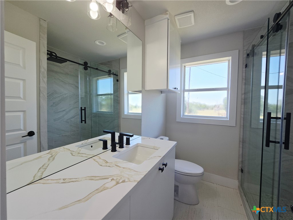 930 Elm Creek Road Rockdale, TX 76567 - Photo 9 of 25 a bathroom with a granite countertop sink toilet and shower
