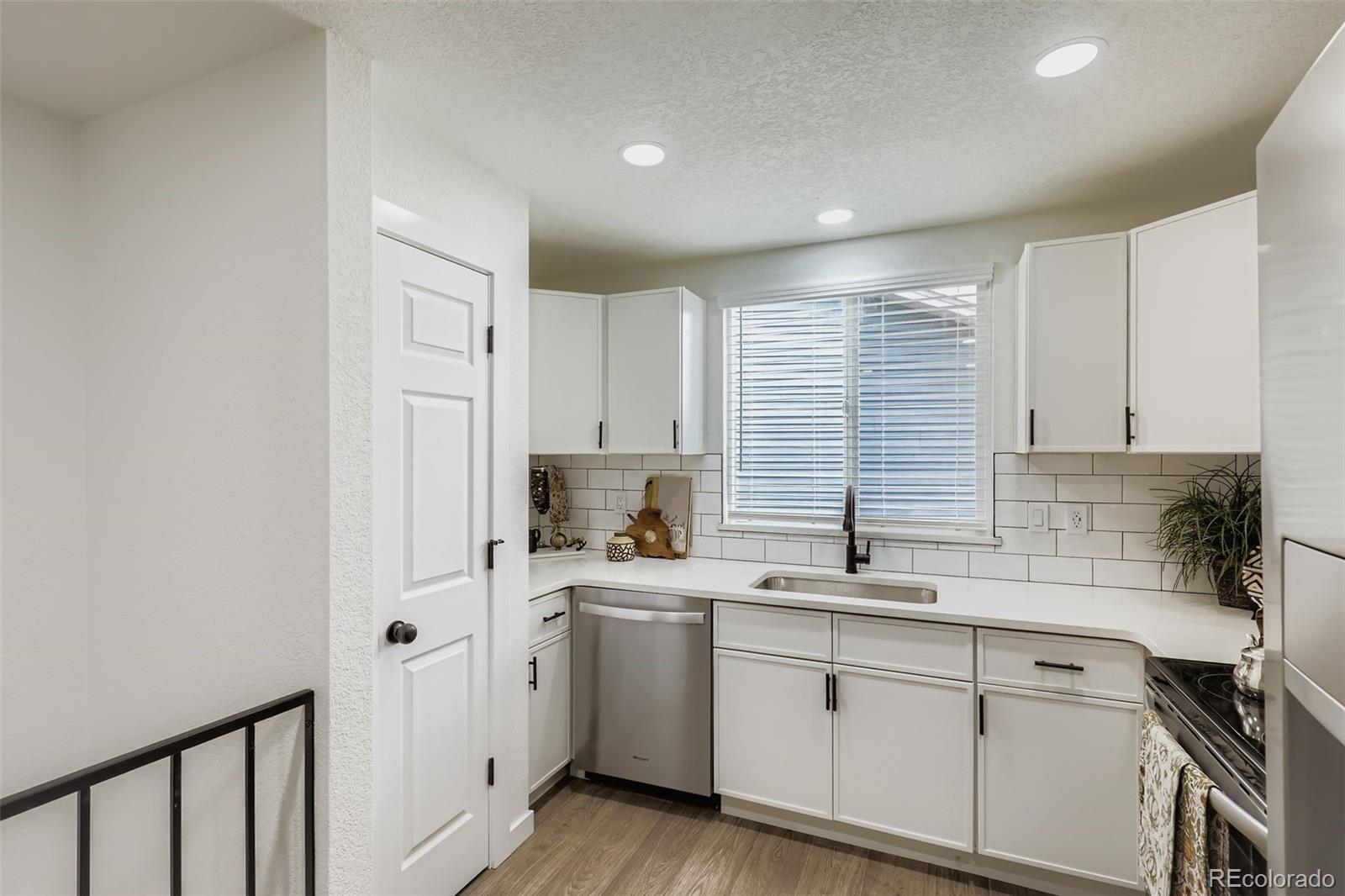 4465 Durham Court Denver, CO 80239 - Photo 12 of 28 a kitchen with a sink cabinets stainless steel appliances and a window