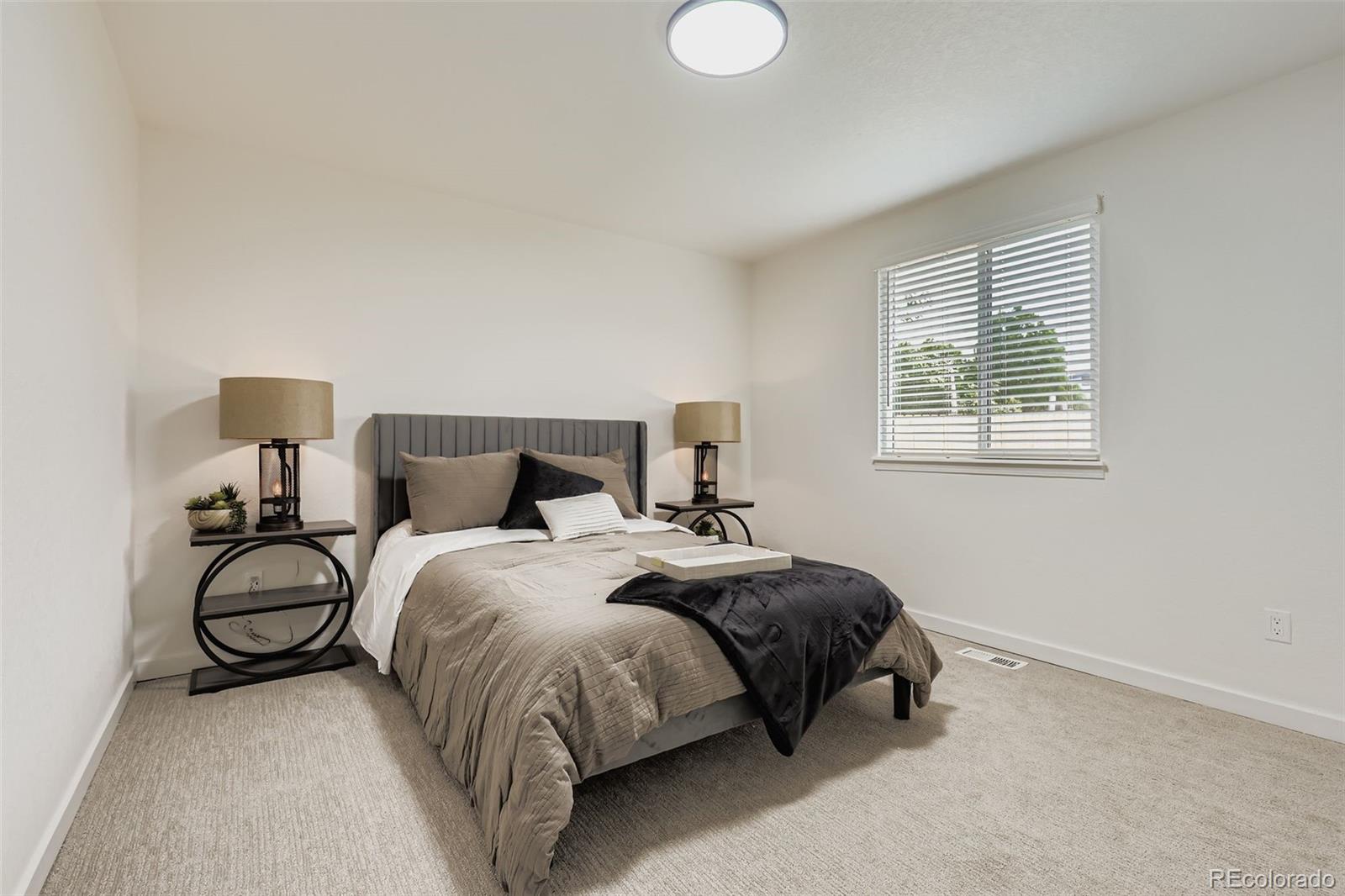 4465 Durham Court Denver, CO 80239 - Photo 14 of 28 a spacious bedroom with a bed and window