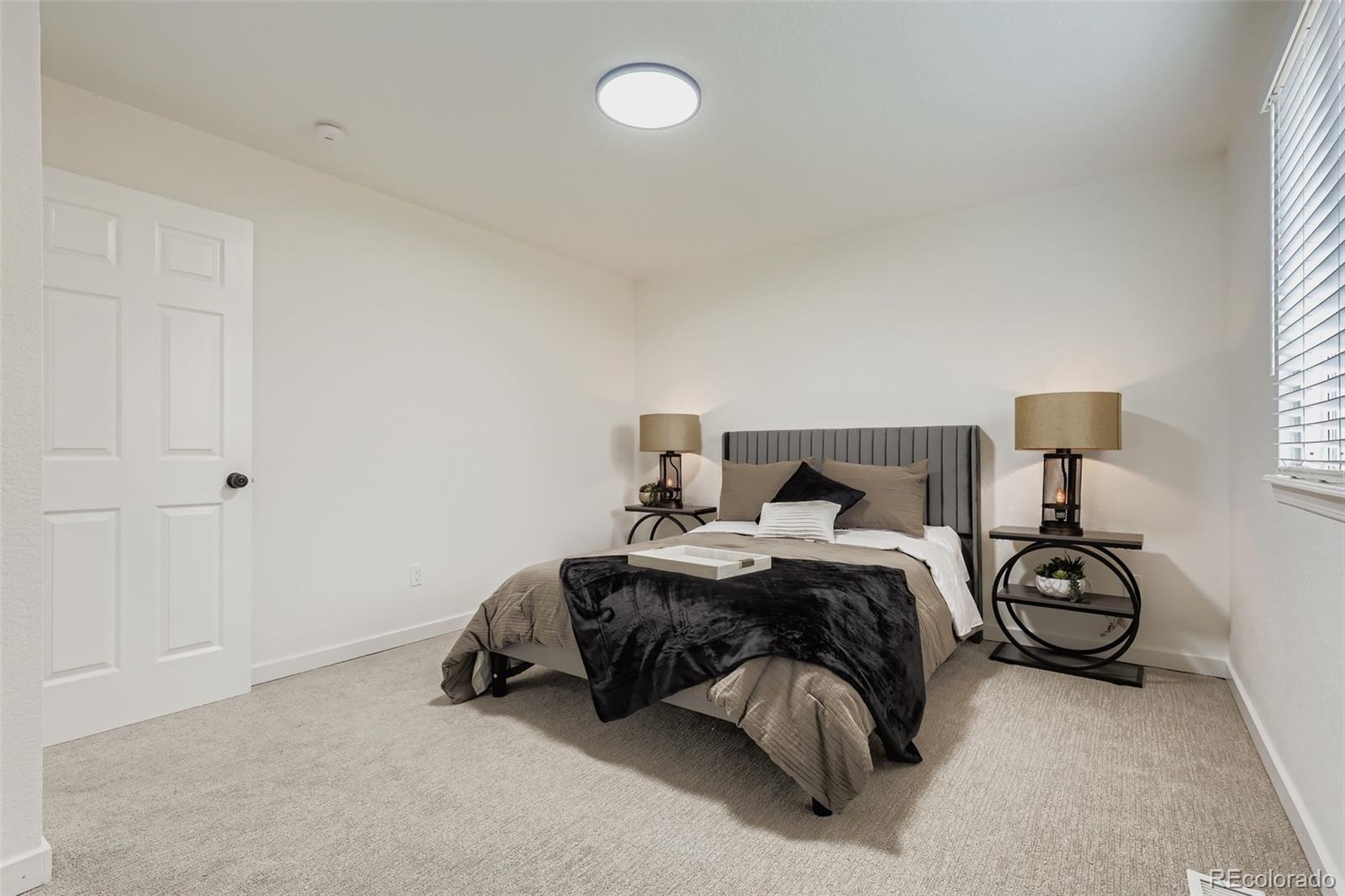 4465 Durham Court Denver, CO 80239 - Photo 15 of 28 a bedroom with a bed and a night stand