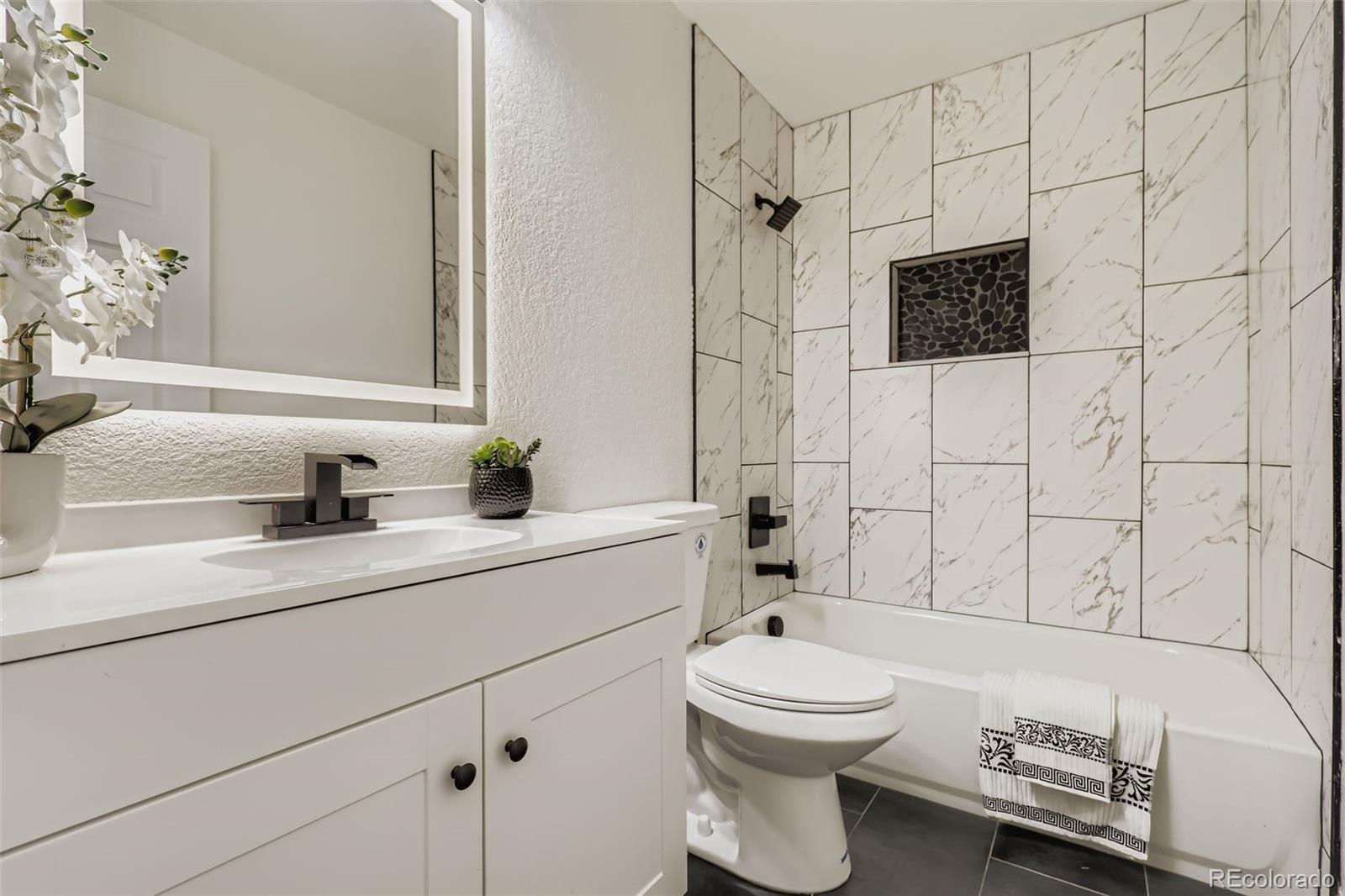 4465 Durham Court Denver, CO 80239 - Photo 18 of 28 a bathroom with a sink a toilet and shower