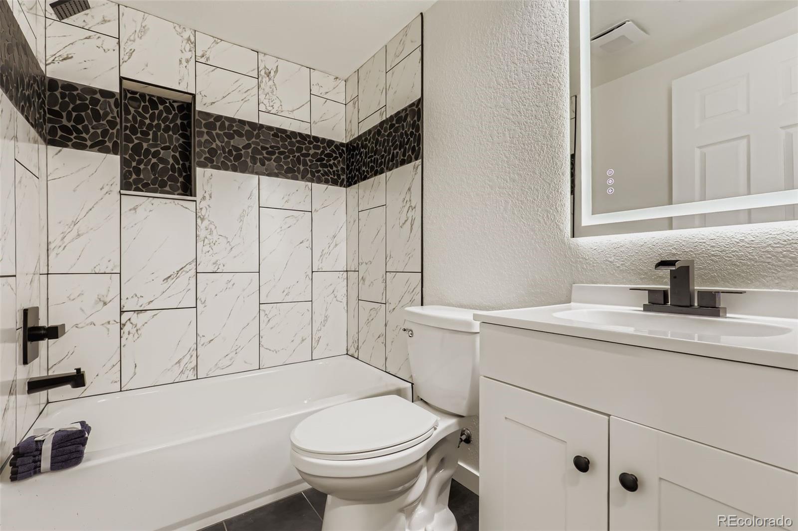 4465 Durham Court Denver, CO 80239 - Photo 24 of 28 a bathroom with a sink toilet vanity and tub