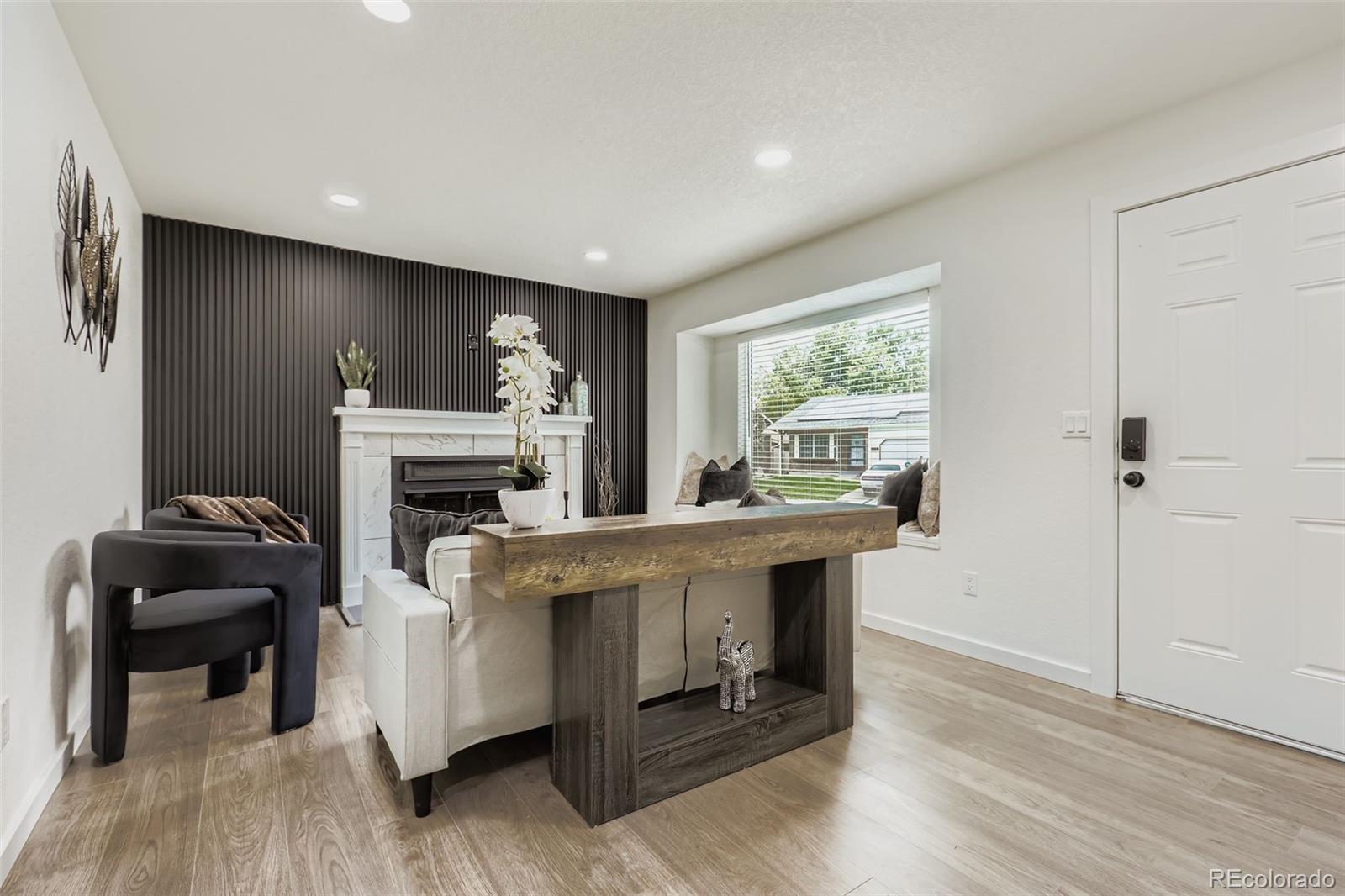 4465 Durham Court Denver, CO 80239 - Photo 7 of 28 a living room with furniture a fireplace and a table