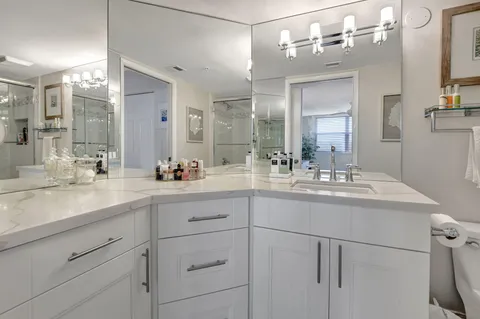a kitchen with white cabinets and sink