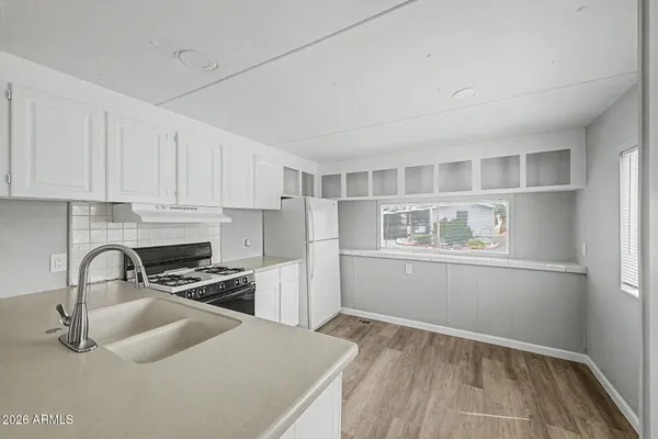 a kitchen with white cabinets and white appliances