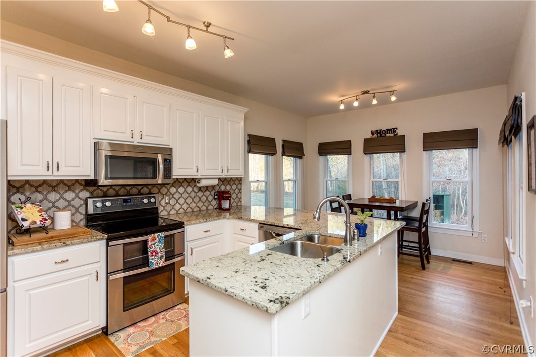 10201 Taylor Road Chesterfield, VA 23838 - Photo 2 of 50 a kitchen with stainless steel appliances granite countertop a sink dishwasher stove and refrigerator with wooden floor