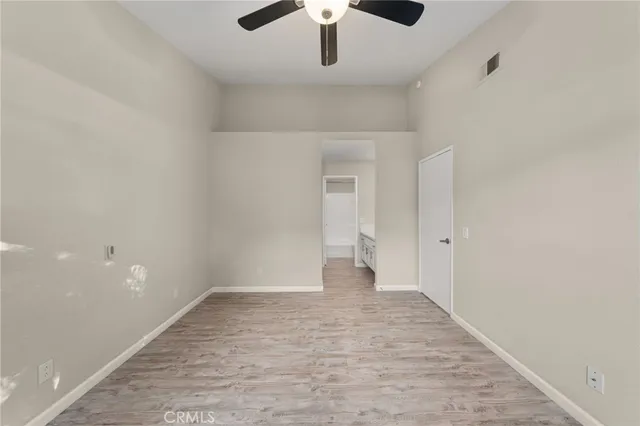 a view of an empty room and chandelier fan