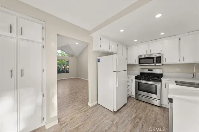 a kitchen with stainless steel appliances a refrigerator sink and microwave