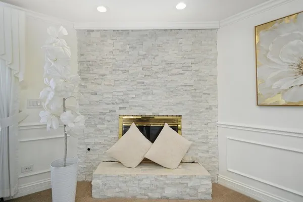 a white bed sitting in a bedroom next to a window and a chandelier