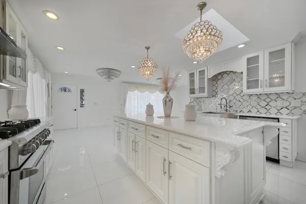a kitchen with cabinets a stove and a clock