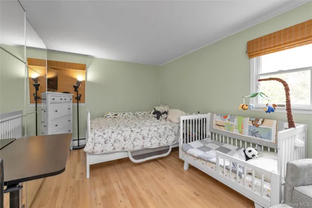 a bedroom with baby crib and windows