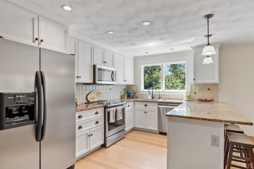 4 Prospect Hill Road Harvard, MA 01451 - Photo 8 of 37 a kitchen with stainless steel appliances granite countertop a stove a sink a refrigerator and white cabinets with wooden floor
