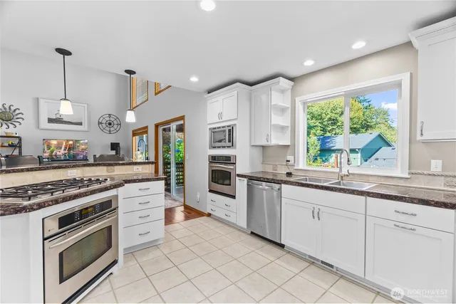 a kitchen with granite countertop white cabinets and white appliances