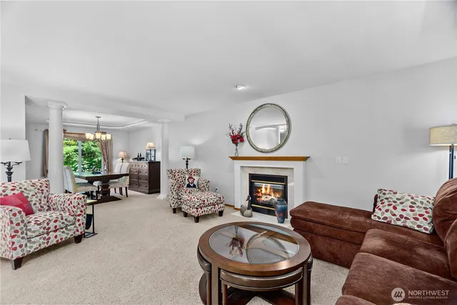 a living room with furniture a fireplace and a floor to ceiling window
