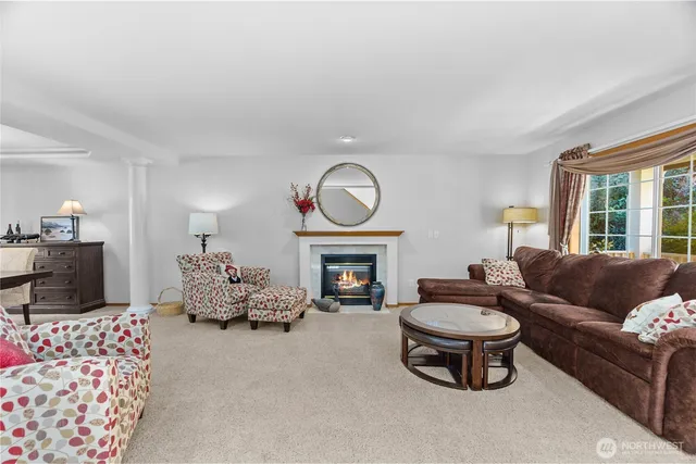 a living room with furniture a fireplace and a large window