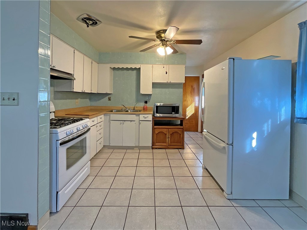 106 Ridgeway Avenue Weirton, WV 26062 - Photo 6 of 19 Kitchen featuring white cabinets, white appliances, exhaust hood, and sink