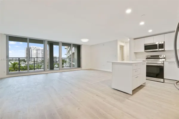 a view of kitchen with stainless steel appliances granite countertop a stove and a sink
