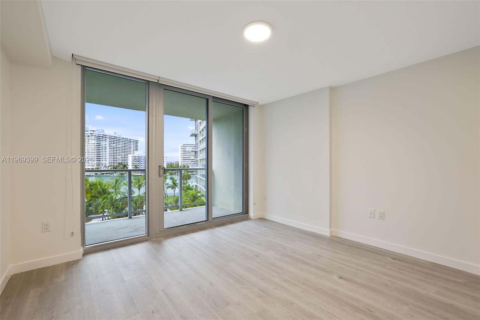 1504 Bay Road, Unit N1208 Miami Beach, FL 33139 - Photo 15 of 84 an empty room with wooden floor and windows