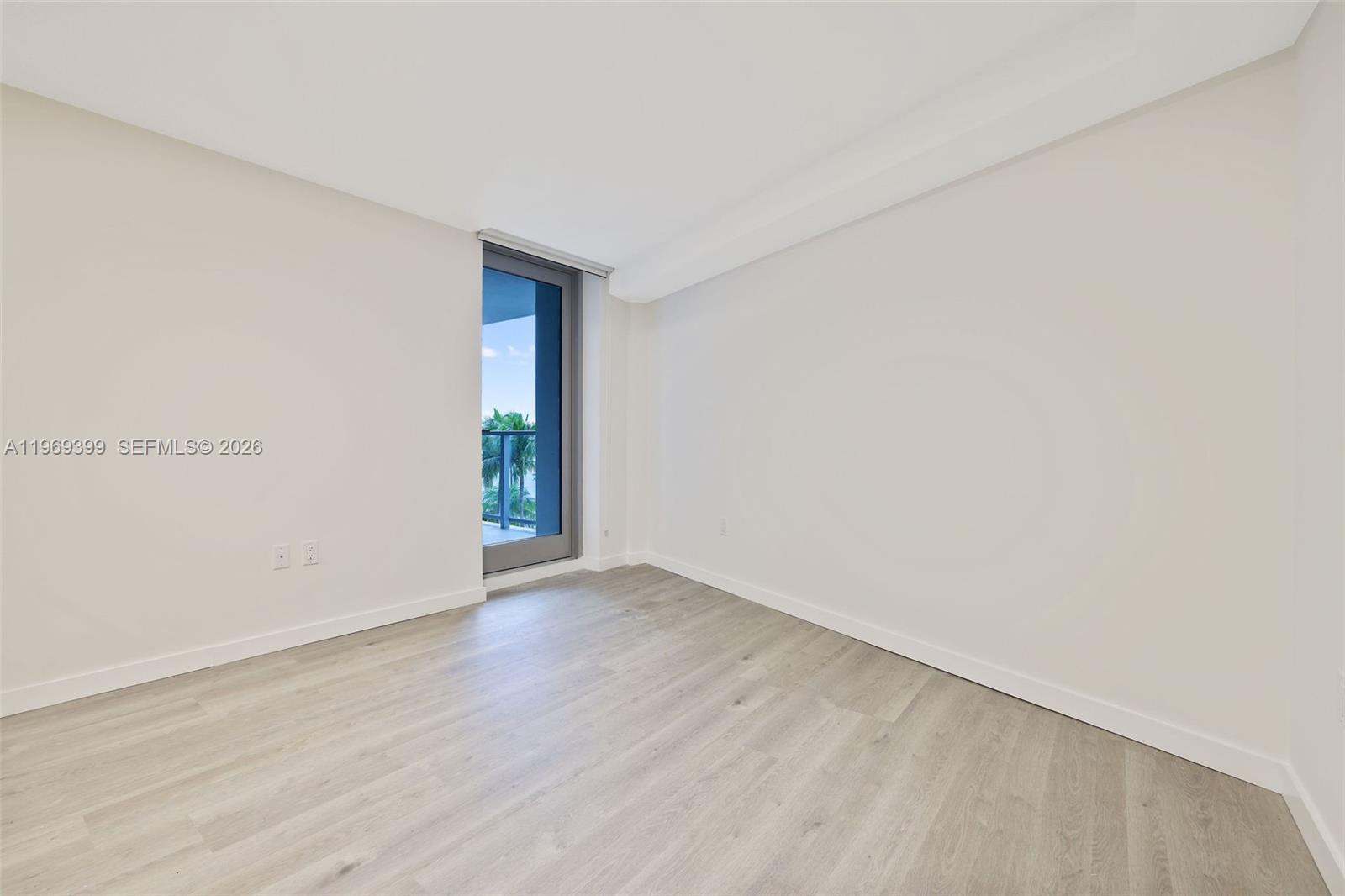 1504 Bay Road, Unit N1208 Miami Beach, FL 33139 - Photo 18 of 84 a view of an empty room with wooden floor and a window