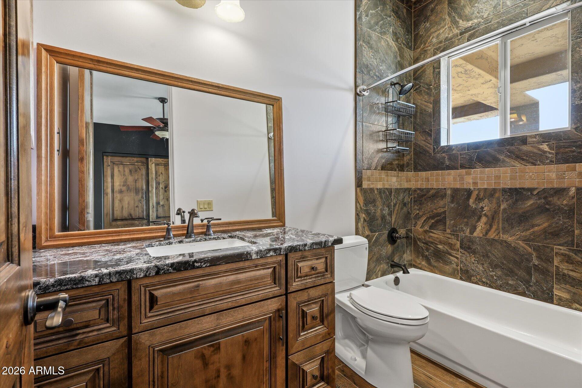 53 North La Barge Road Apache Junction, AZ 85119 - Photo 23 of 40 a bathroom with a granite countertop toilet sink and mirror