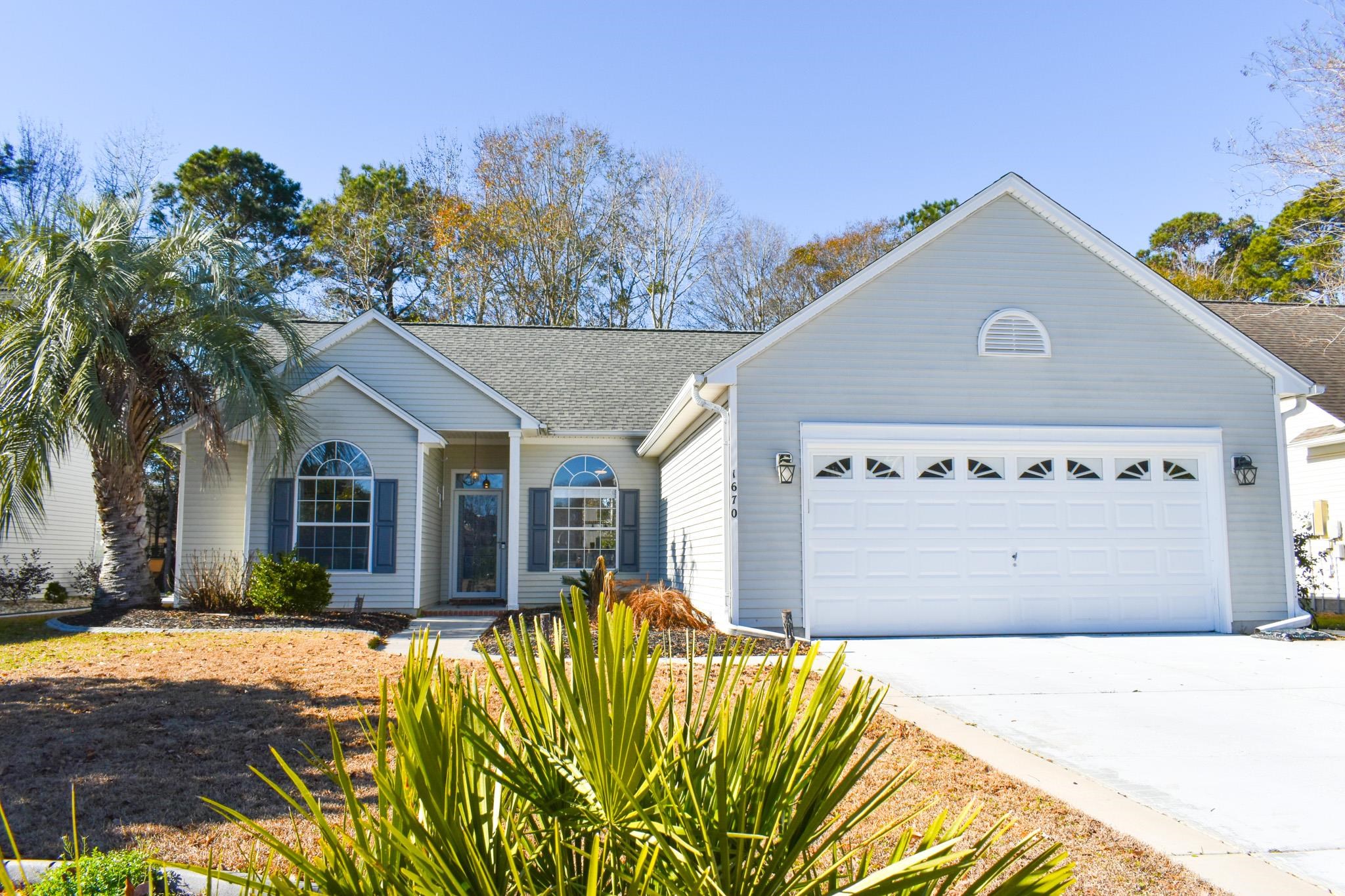 Single story home with concrete driveway, a shingled roof, and an attached garage