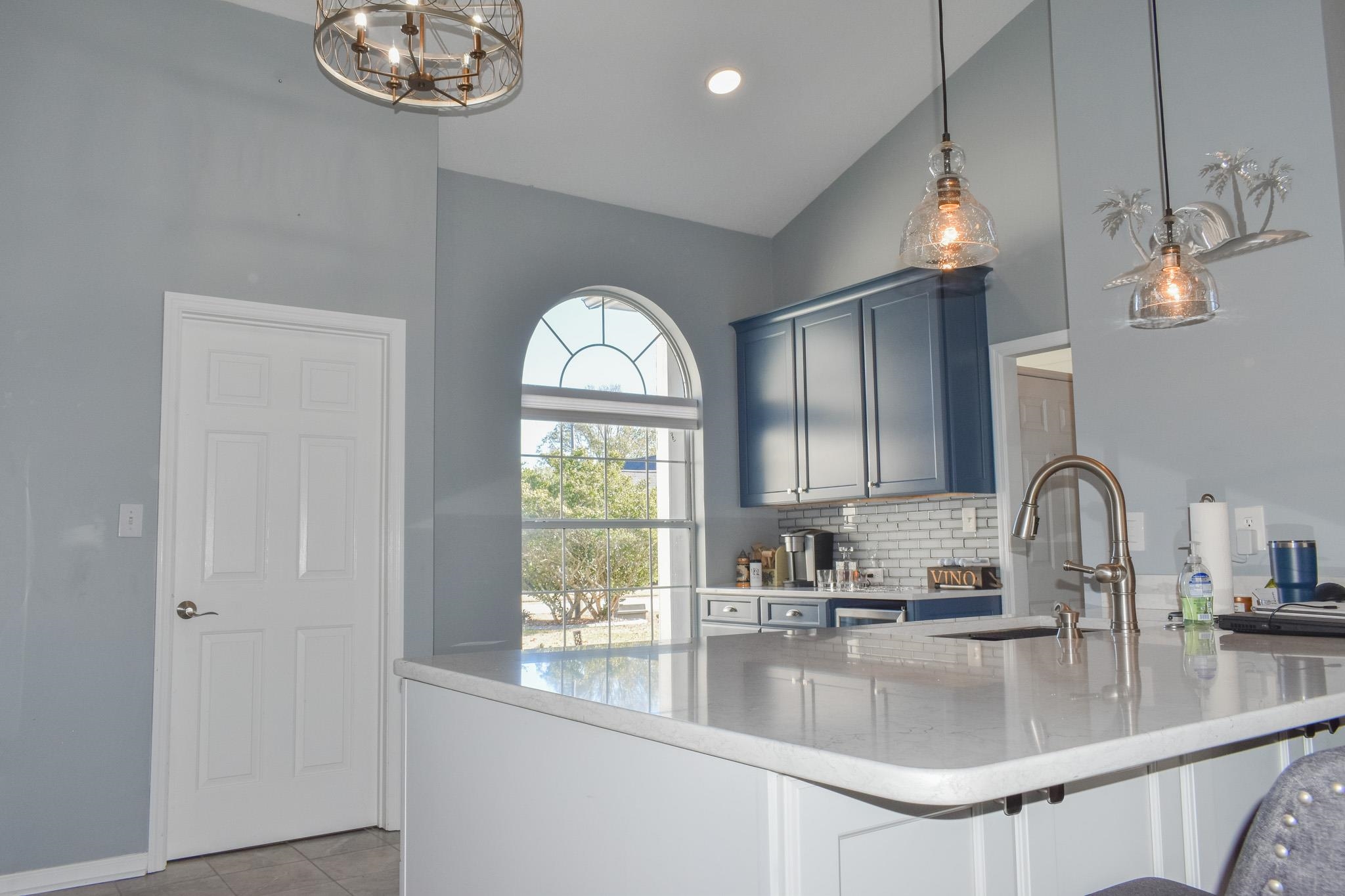 1670 Sedgefield Drive Murrells Inlet, SC 29576 - Photo 7 of 14 Kitchen featuring vaulted ceiling, pendant lighting, decorative backsplash, a kitchen bar, and light stone countertops