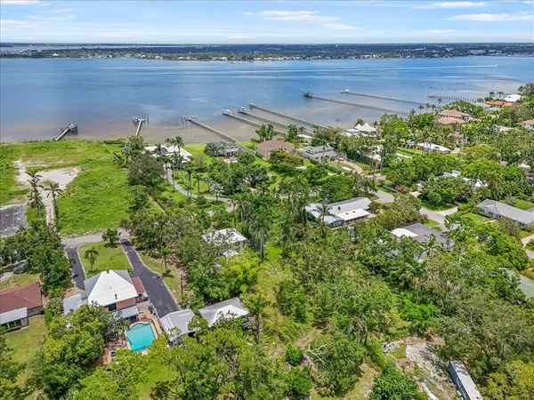 an aerial view of a house with a yard and lake view