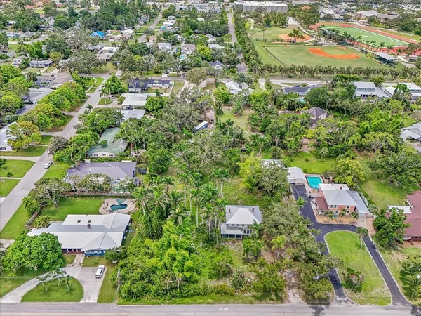 an aerial view of residential houses with outdoor space and trees