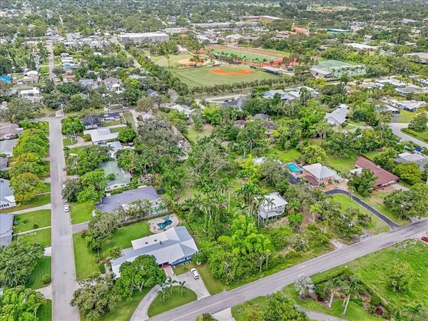 an aerial view of residential houses with outdoor space and trees