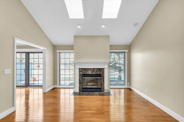 a view of a livingroom with a fireplace wooden floor and windows