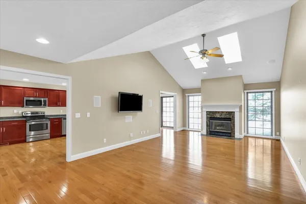 a view of a livingroom with a flat screen tv a fireplace and wooden floor